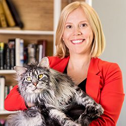 Heather-Ridill_2024_250x250 A woman smiling, holding a large cat