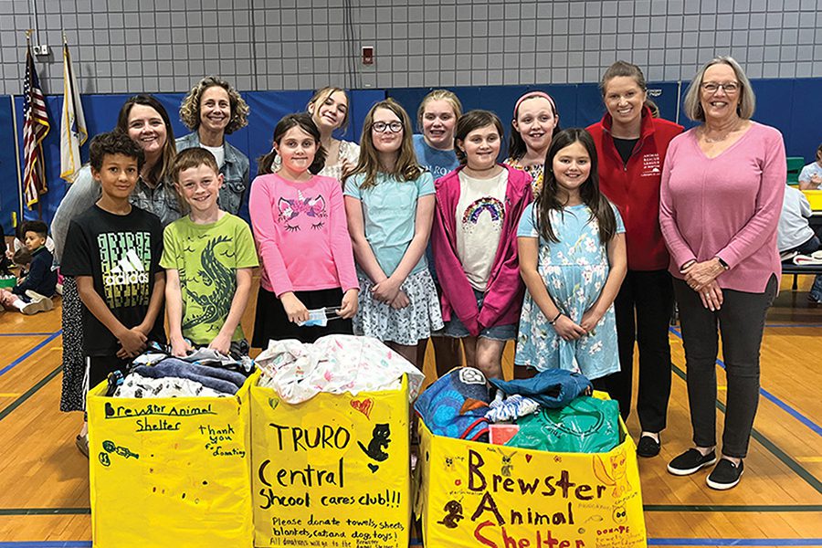 brewster-fundraiser-website A group of children and adults standing behind boxes full of donated items