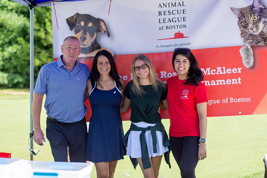 golf-fundraiser-website three people posing next to each other outside in front of an ARL banner