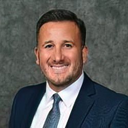 dan-menendez-250×250 A person smiling, wearing a suit